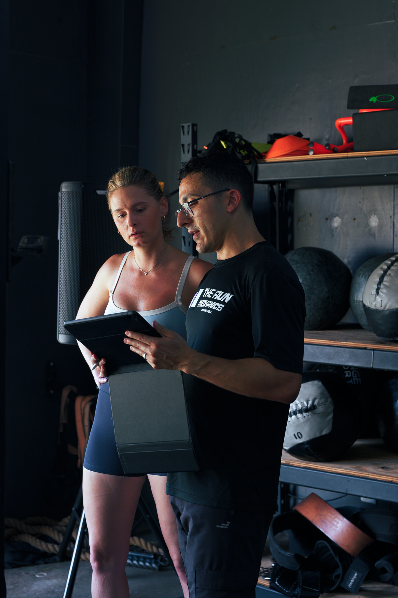 Daniel reviewing gait video on a tablet with a client in the gym